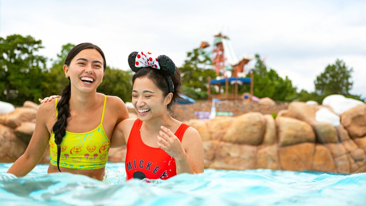 Two friends with their arms around each other’s shoulders as they enjoy Melt Away Bay at Disney's Blizzard Beach water park