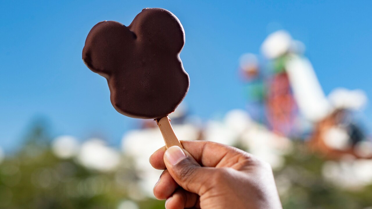 A hand holding a Mickey Mouse ice cream bar at Disney’s Blizzard Beach water park