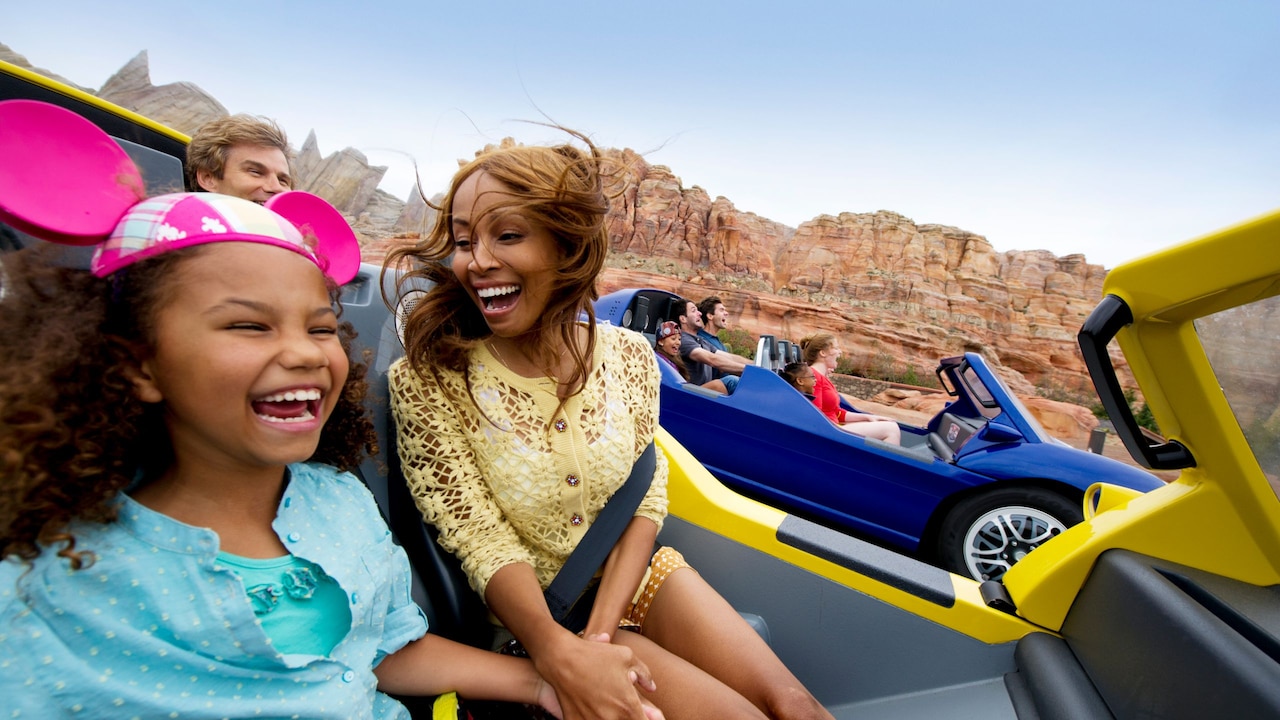 Guests smiling as they ride Radiator Springs Racers