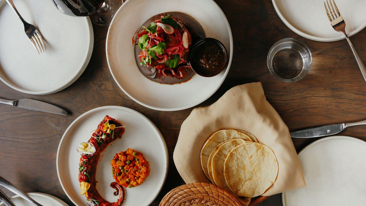A table set with several Mexican dishes and beverages