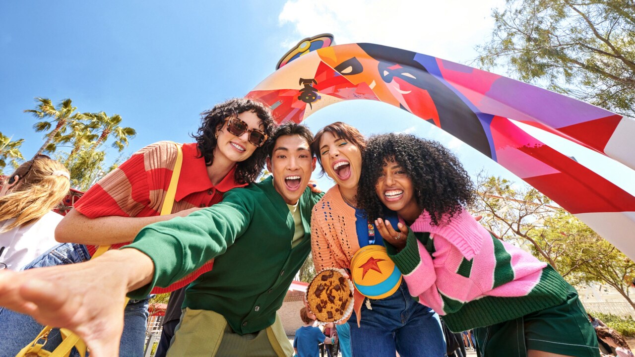 Four Guests posing for a selfie under the archway of the Incredicoaster attraction
