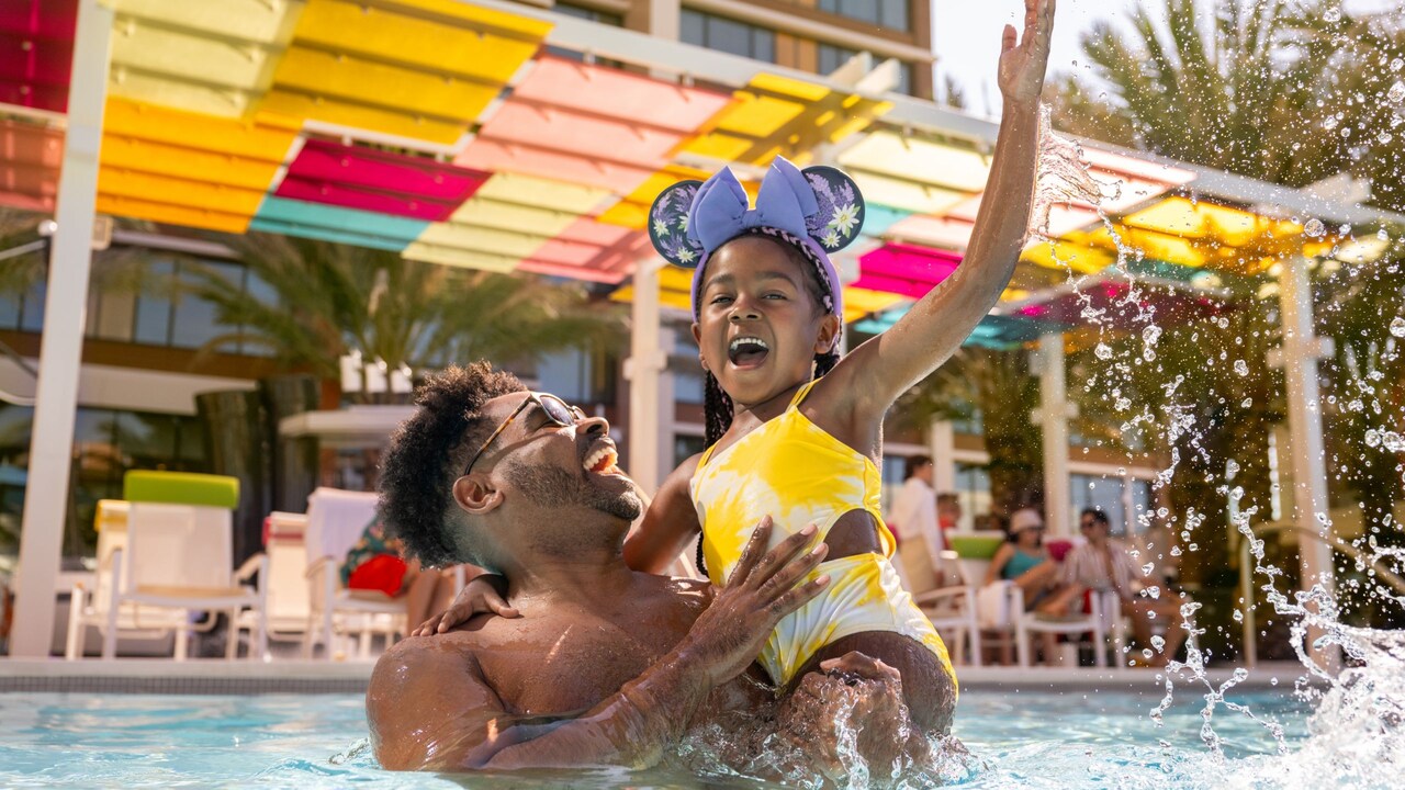 A father playing with his daughter in the Palette Pool at the Villas at Disneyland Hotel