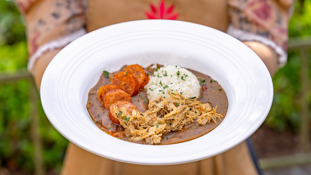 A person holding a bowl of the House Gumbo from Tiana’s Place