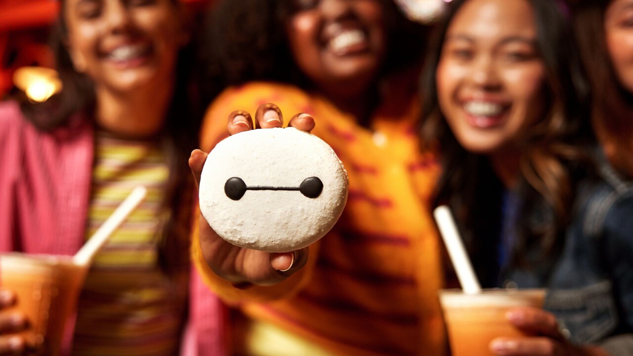 Three Guests holding beverages and a Baymax Macaron from Lucky Fortune Cookery