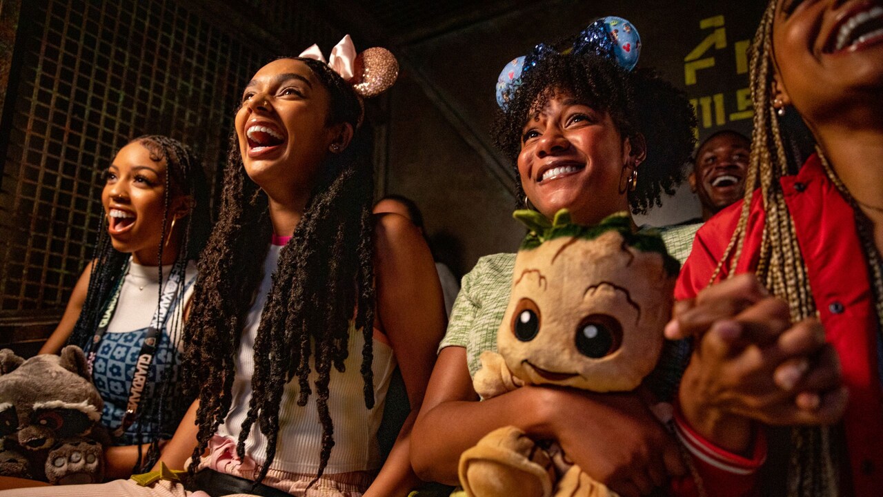 Guests holding a plush Rocket Racoon and Groot while riding Guardians of the Galaxy Mission Breakout