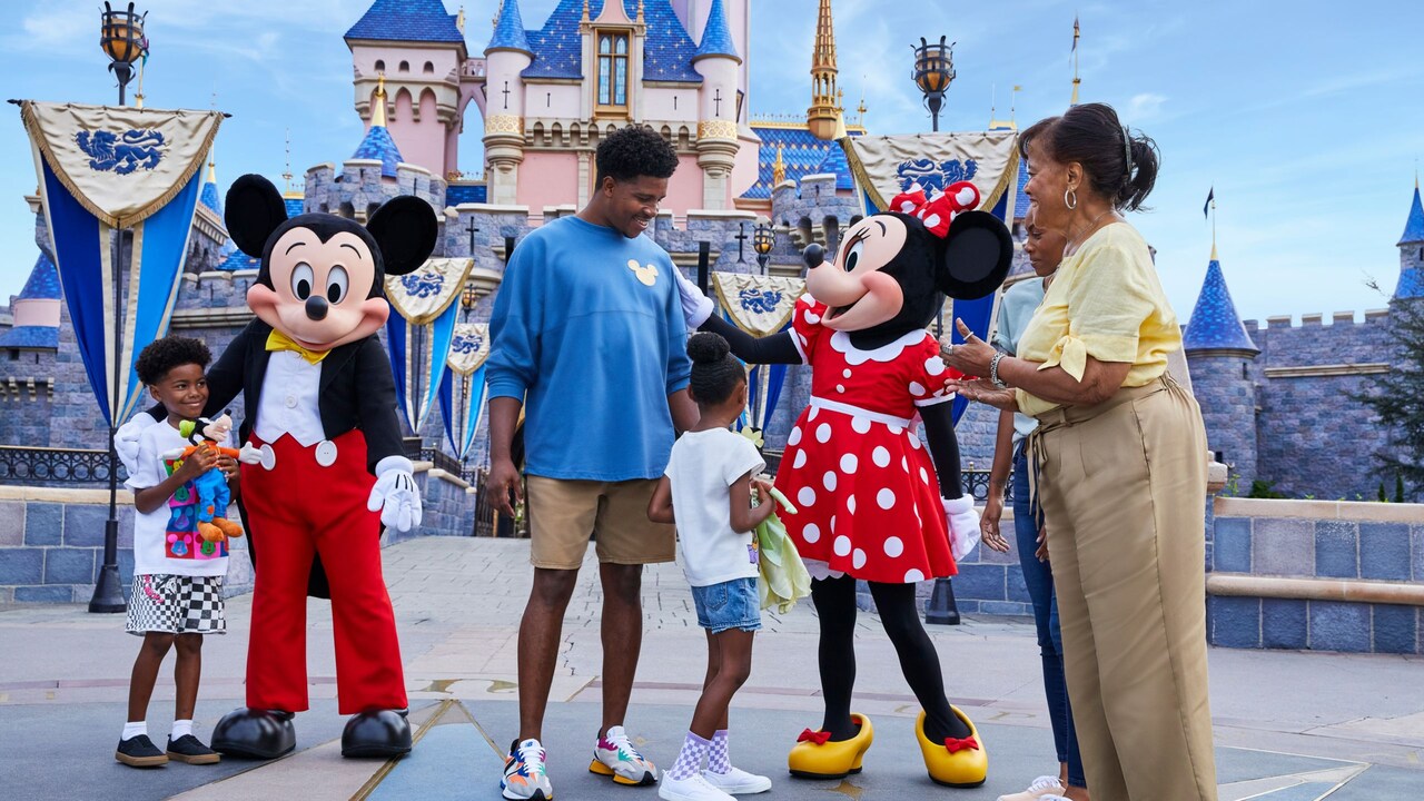 Guests greeting Mickey Mouse and Minnie Mouse in front of Sleeping Beauty Castle