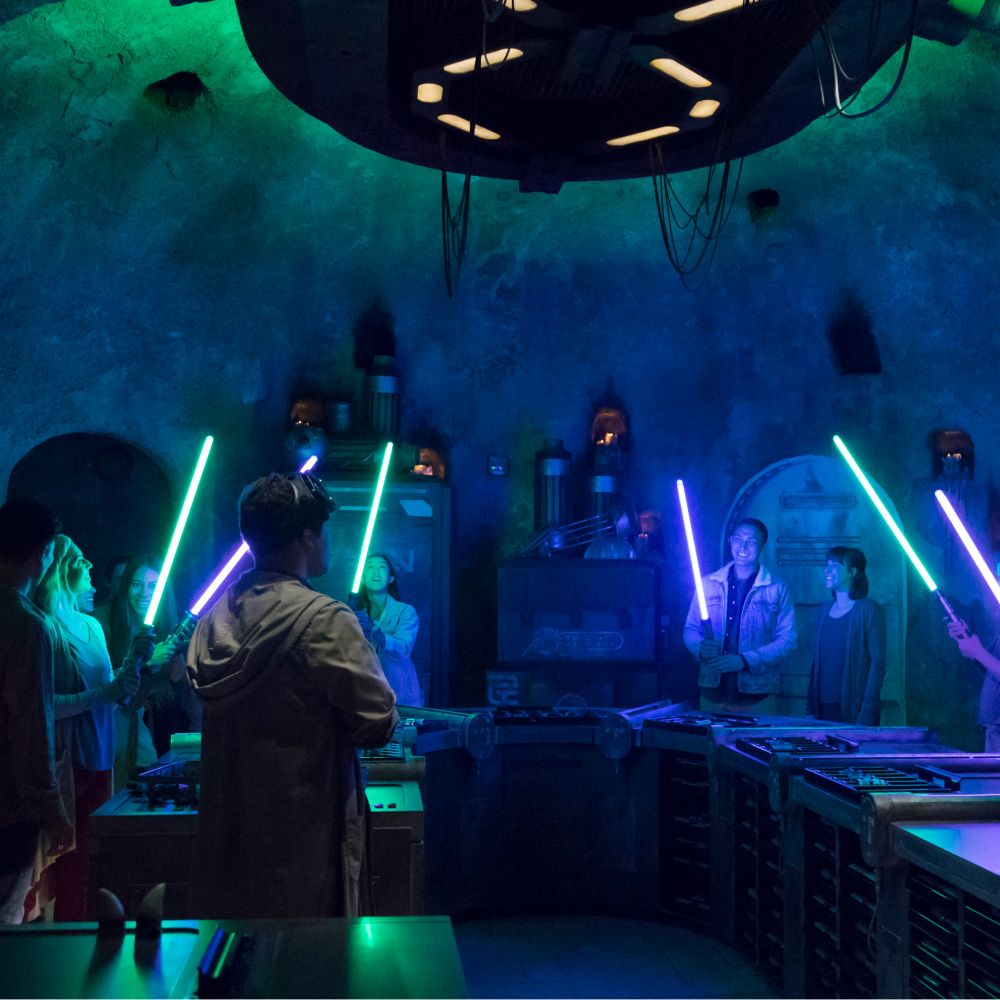 Un grupo de Visitantes hace sables de luz en Savi’s Workshop, en Star Wars: Galaxy’s Edge