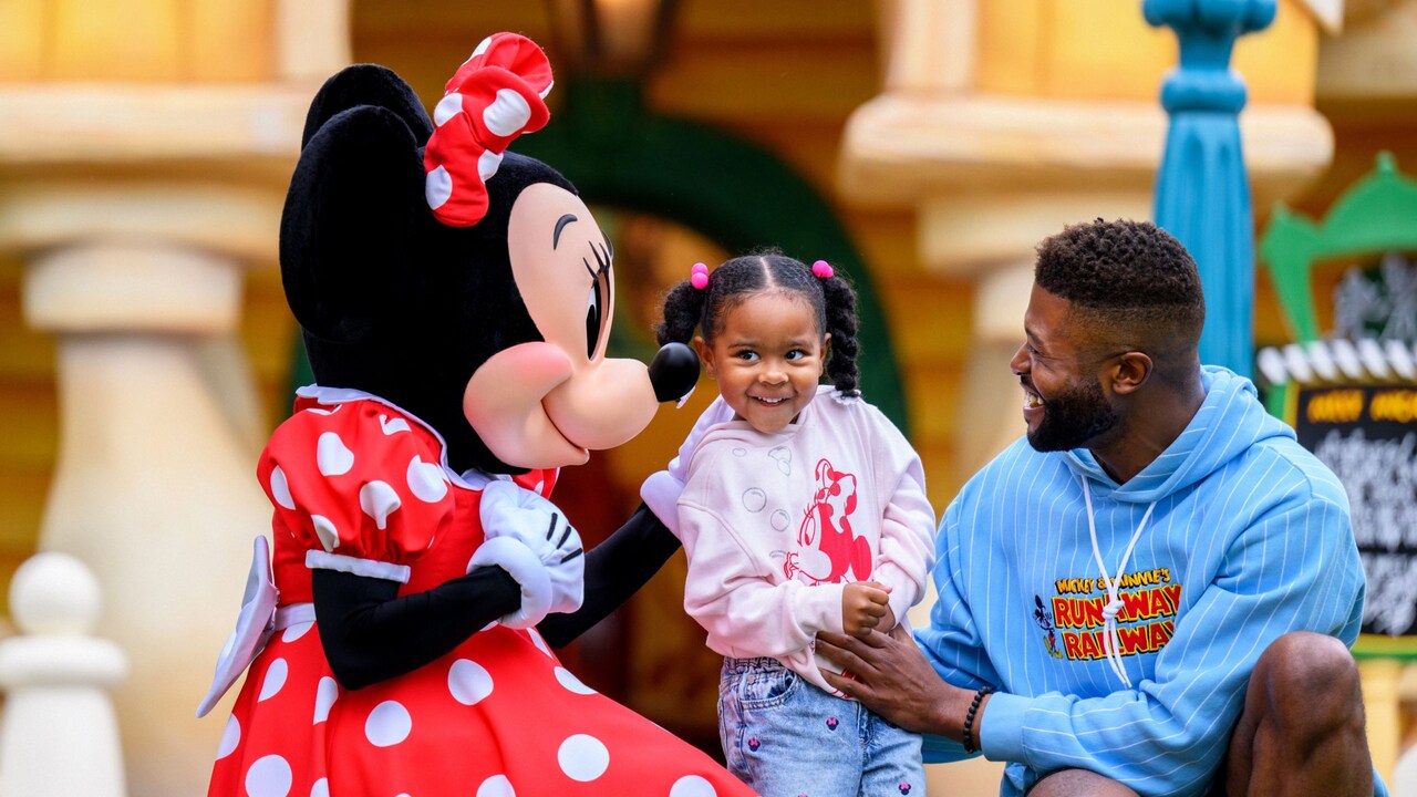 Father and daughter meet Minnie at the Disneyland Resort
