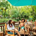 A family of 6 relaxing on a deck next to Cross Country Creek at Disney's Blizzard Beach water park