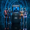 4 TRON inspired action figures beside a TRON themed arcade game