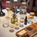 A tequila tasting flight with labeled glasses, garnishes and a wooden pairing board  