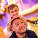 A child sitting on his father’s shoulders at Main Street U S A in Magic Kingdom park