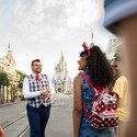 A VIP Tour Guide and Guests walking down Main Street, USA with Cinderella Castle in the distance