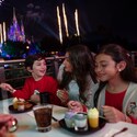 A mother with her two young children enjoying desserts at an outdoor dining table