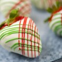 A plate of strawberries dipped in white chocolate and decorated with chocolate drizzle