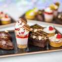 Assorted mini desserts including brownies, tarts and treats arranged on a tray