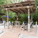 A covered lounge outdoors featuring chairs and tables at Disney’s Typhoon Lagoon water park