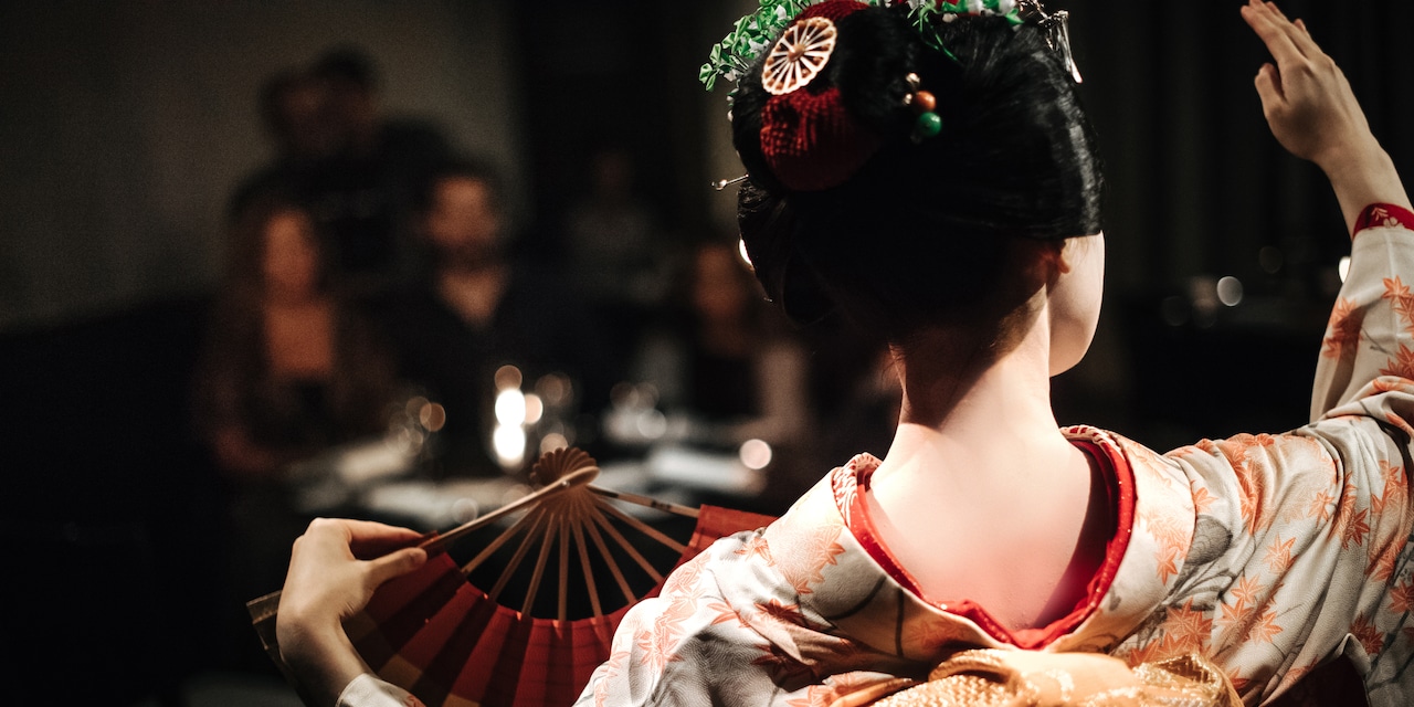 A Maiko in traditional dress with a fan performs A Maiko in traditional dress with a fan performs
