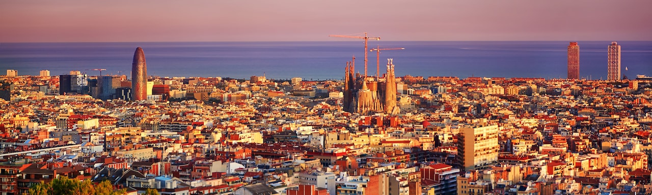 A view of the city of Barcelona with the Sagrada Famíla in the center and the Balearic Sea in the distance A view of the city of Barcelona with the Sagrada Famíla in the center and the Balearic Sea in the distance