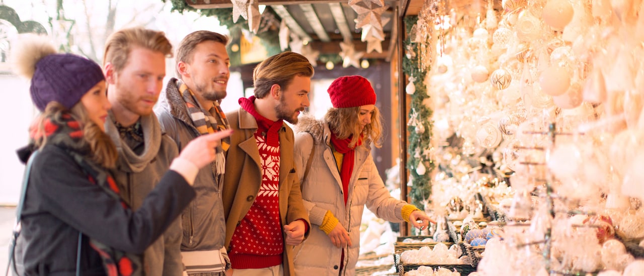3 men and 2 women look at delicate ornaments at a Christmas Market 3 men and 2 women look at delicate ornaments at a Christmas Market
