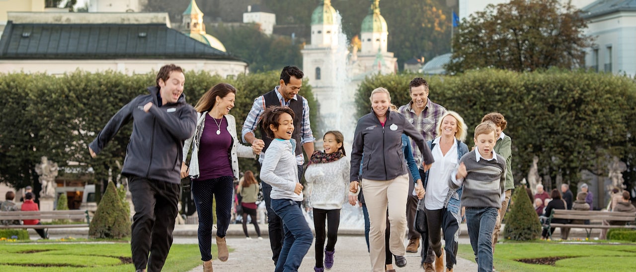 2 families happily stroll down a path by a fountain near historic buildings 2 families happily stroll down a path by a fountain near historic buildings