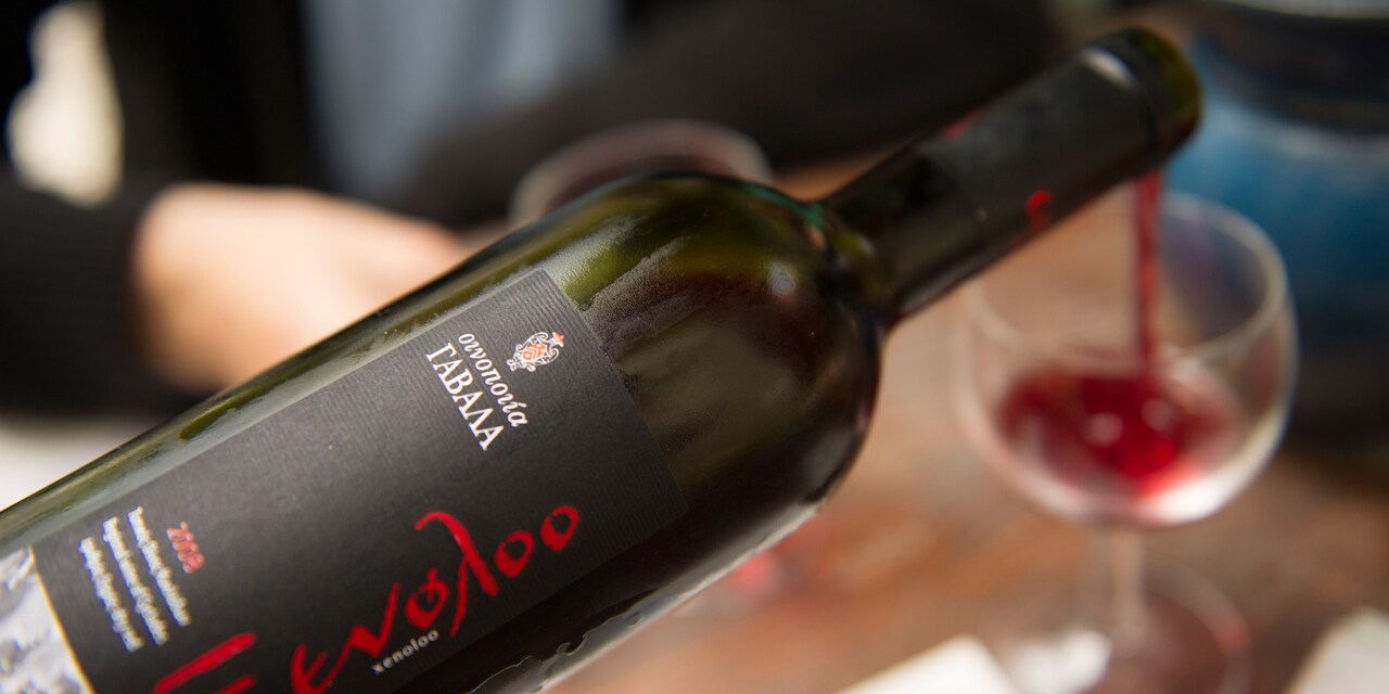 A Greek wine is being poured into a wine glass A Greek wine is being poured into a wine glass