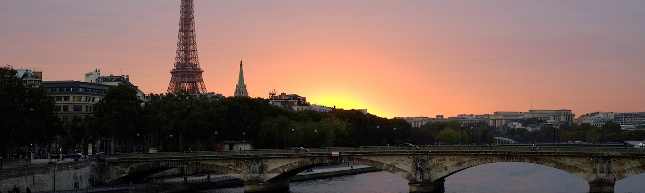 A bridge over the Seine River and the Eiffel Tower at sunset A bridge over the Seine River and the Eiffel Tower at sunset