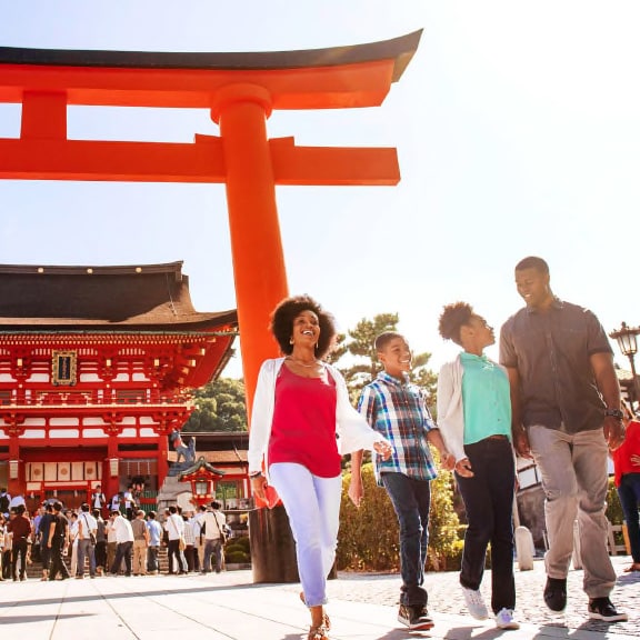 A family of 3 and an Adventure Guide walk in front of the Fushimi Inari Shrine in Kyoto, Japan A family of 3 and an Adventure Guide walk in front of the Fushimi Inari Shrine in Kyoto, Japan