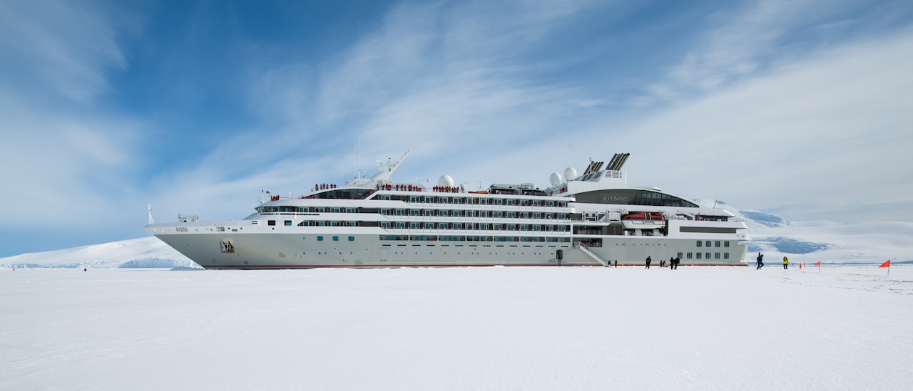 Cruise ship with disembarkation gangway to the snowy shore of Antarctica