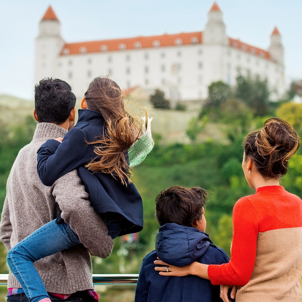 A family of 4 looks at a building on a hill A family of 4 looks at a building on a hill