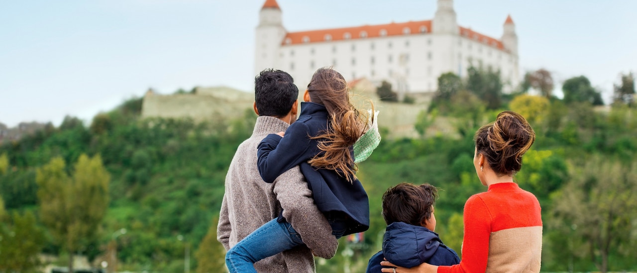 A family of 4 looks at a building on a hill A family of 4 looks at a building on a hill