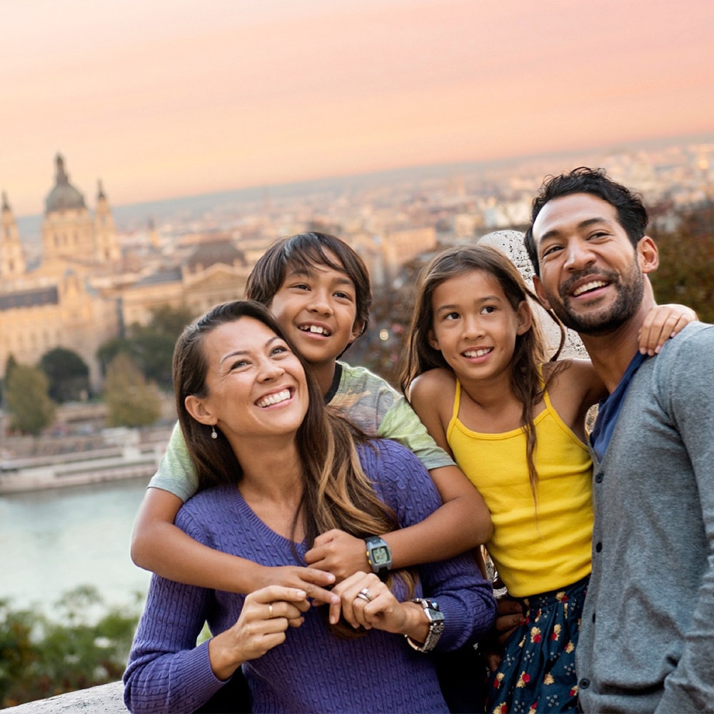 A family of 4 above a city look around with a sense of excitement A family of 4 above a city look around with a sense of excitement
