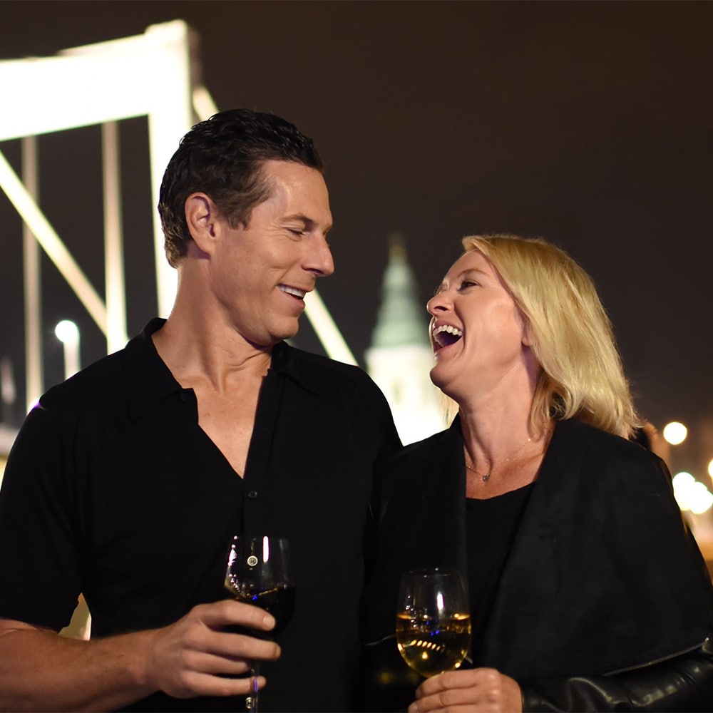 A laughing couple drinks wine A laughing couple drinks wine