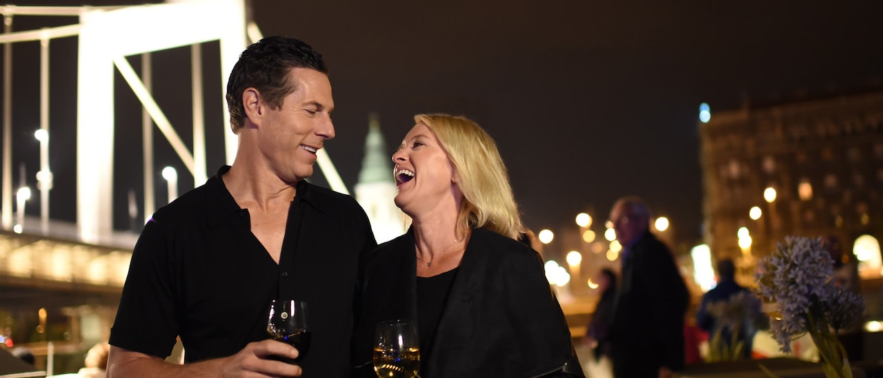 A laughing couple drinks wine A laughing couple drinks wine