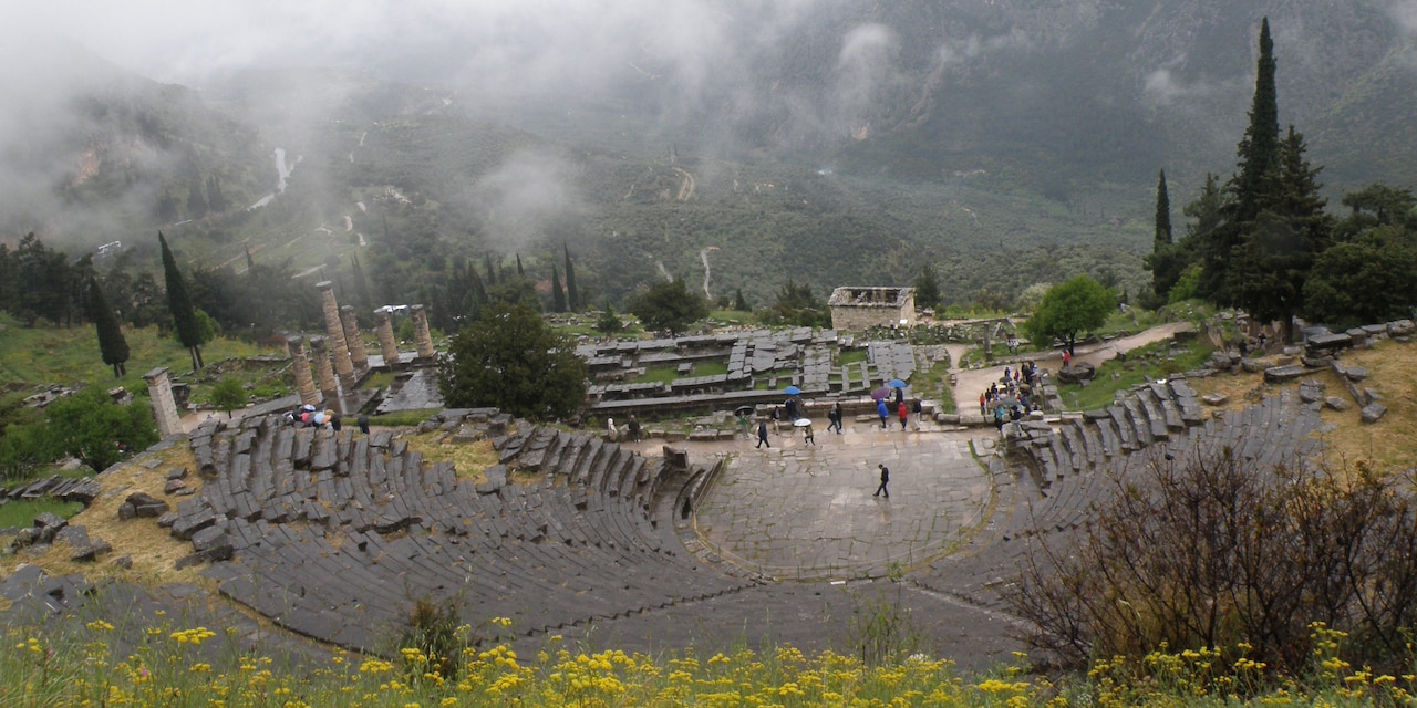Tourists explore the Theatre of Delphi on a misty day Tourists explore the Theatre of Delphi on a misty day