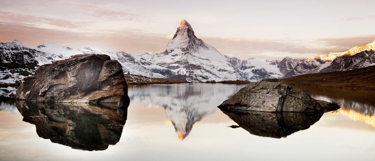 The famed, snow dusted Matterhorn and a rock studded lake
