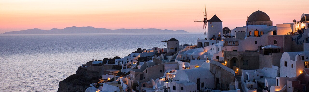 Buildings of the cliffside city of Santorini, Greece overlooking the Mediterranean Sea at nighttime Buildings of the cliffside city of Santorini, Greece overlooking the Mediterranean Sea at nighttime