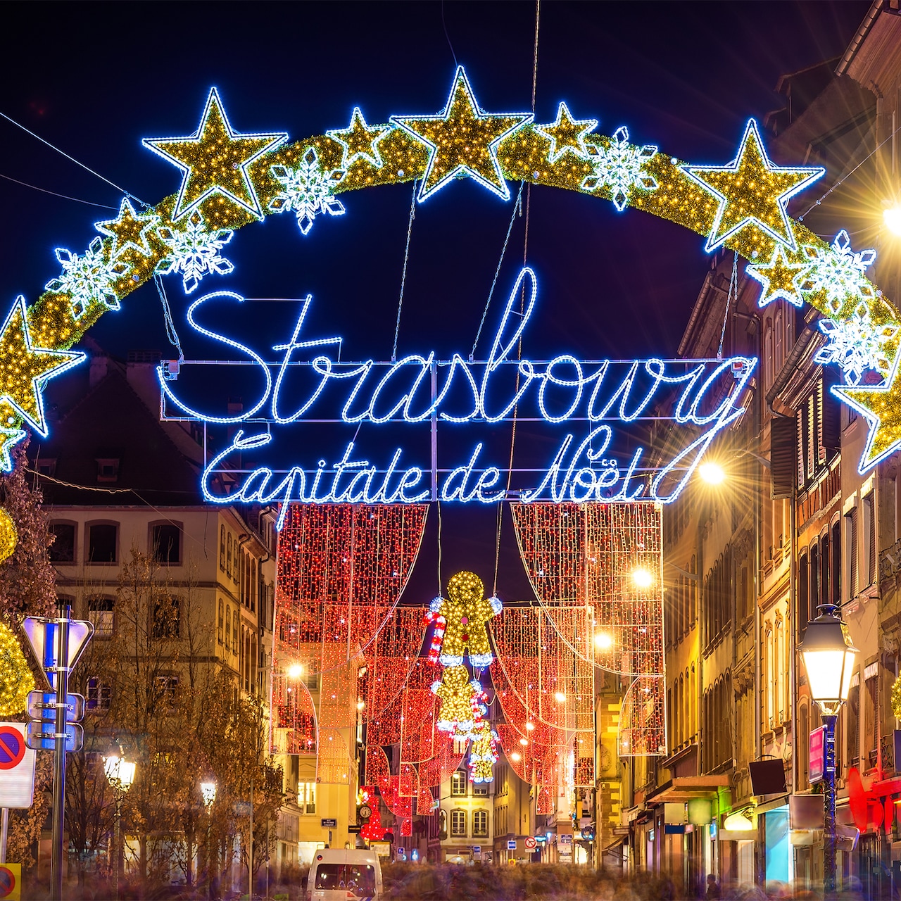 A lit-up sign between two buildings says Strasbourg Capitale de Noel