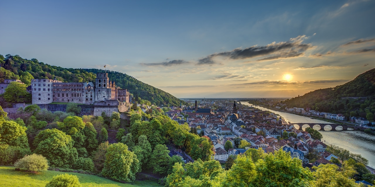 A castle looms over a charming town on a river