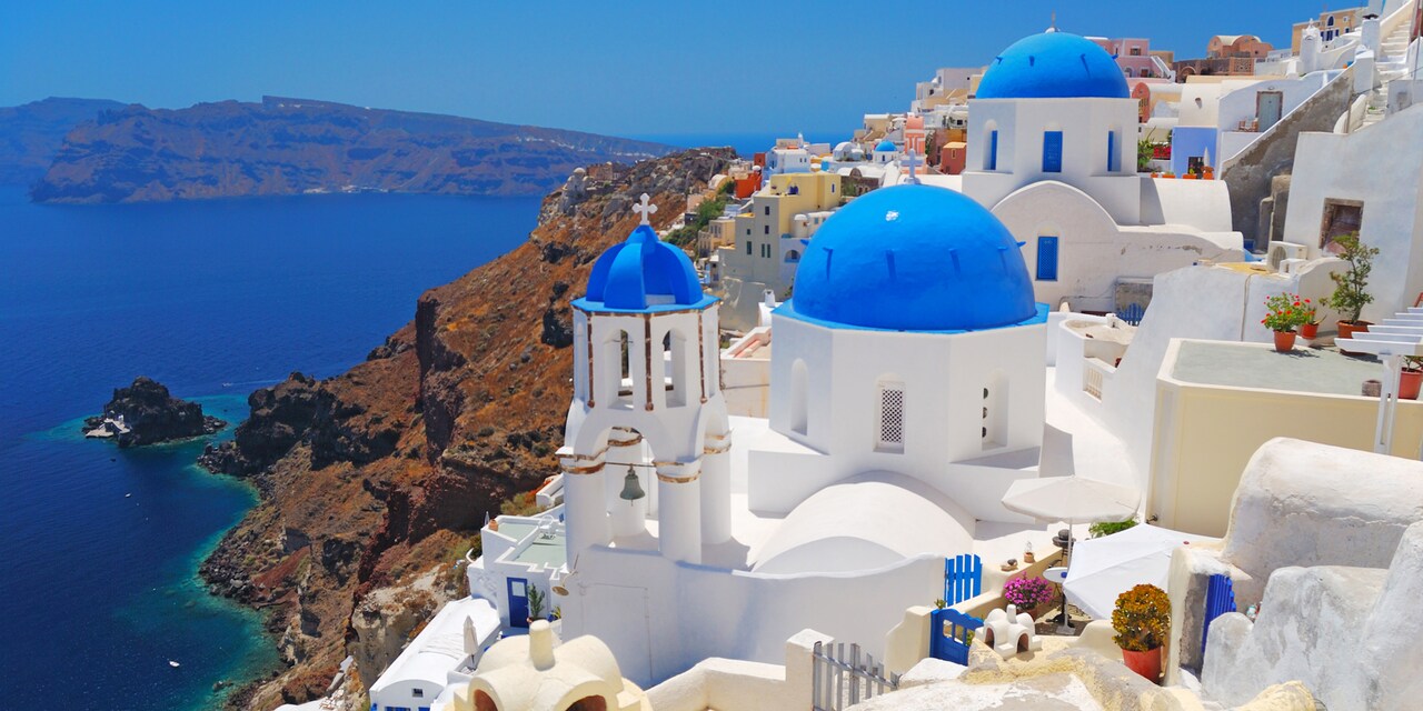 Santorini in Greece featuring buildings built along the mountains overlooking the Mediterranean Sea