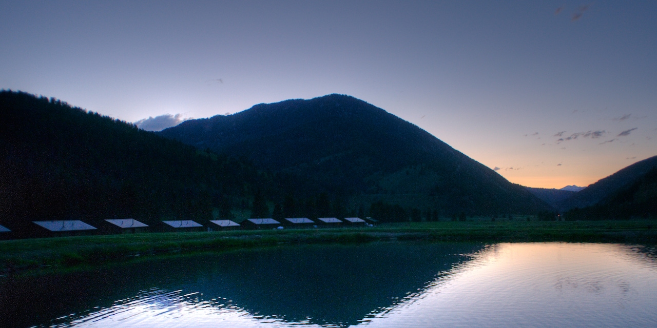Cabins by a river at daybreak