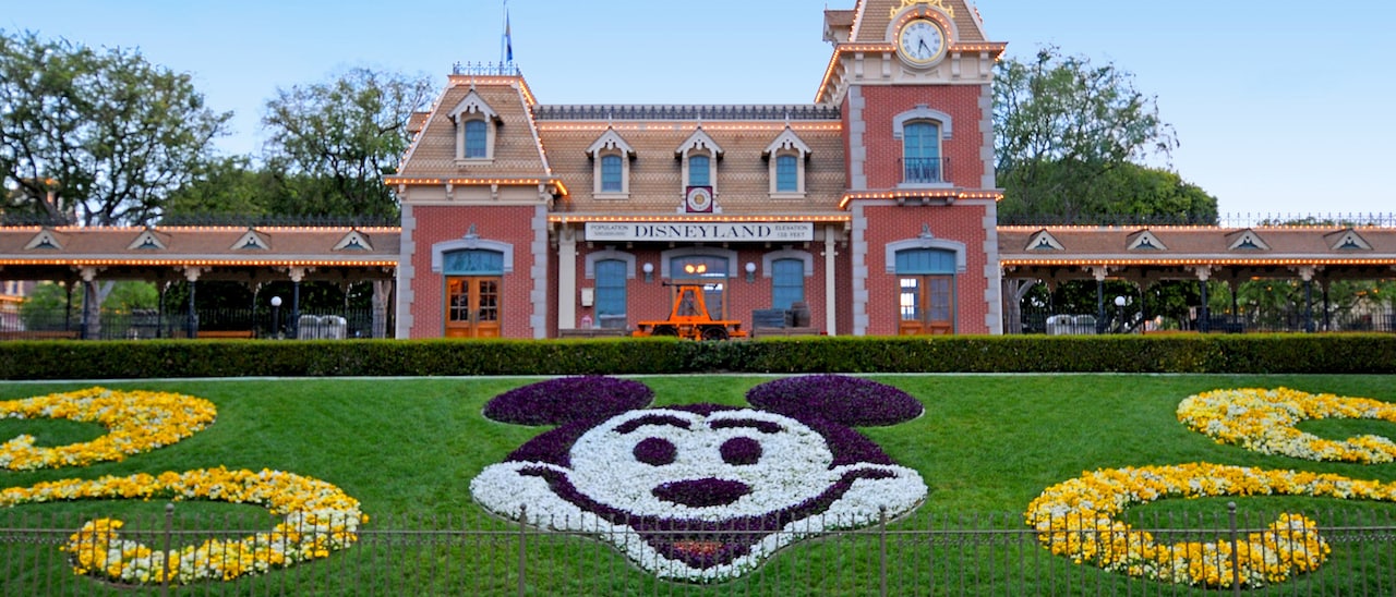 The Main Entrance to Disneyland Park with the train station and floral Mickey display