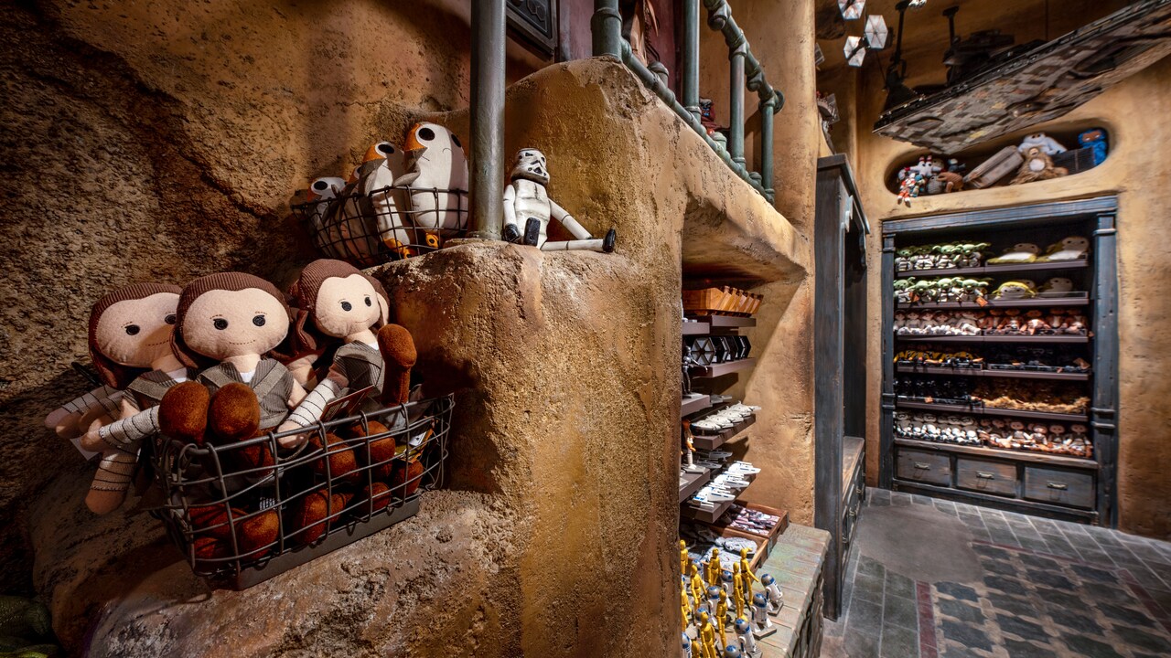 Shelves of toys inside Toydarian Toymaker include wooden action figures and plush toys of popular Star Wars characters.