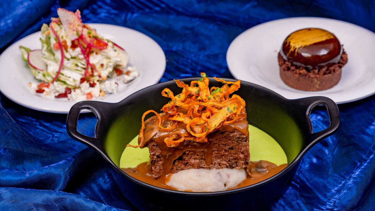 Una ensalada de cuña pequeña, un pastel de carne glaseado con salsa de champiñones y un pastel de chocolate, todo parte del Paquete de Comida Paint  The Night de Plaza Inn
