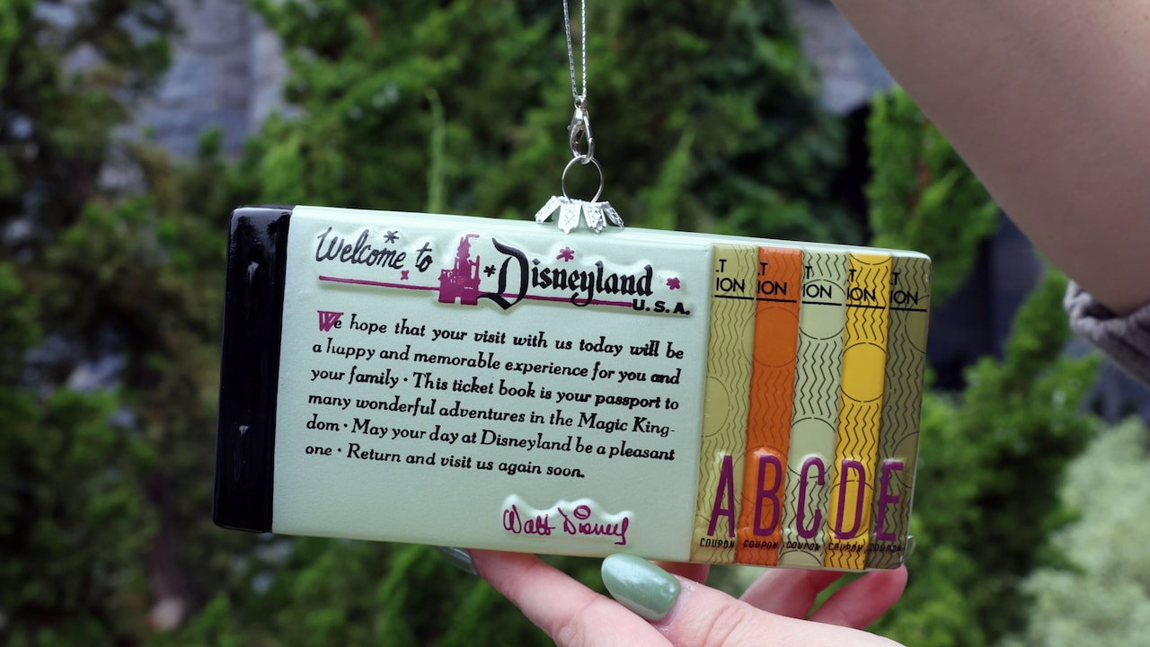 An ornament resembling a ticket book commemorating the Disneyland 70th Celebration