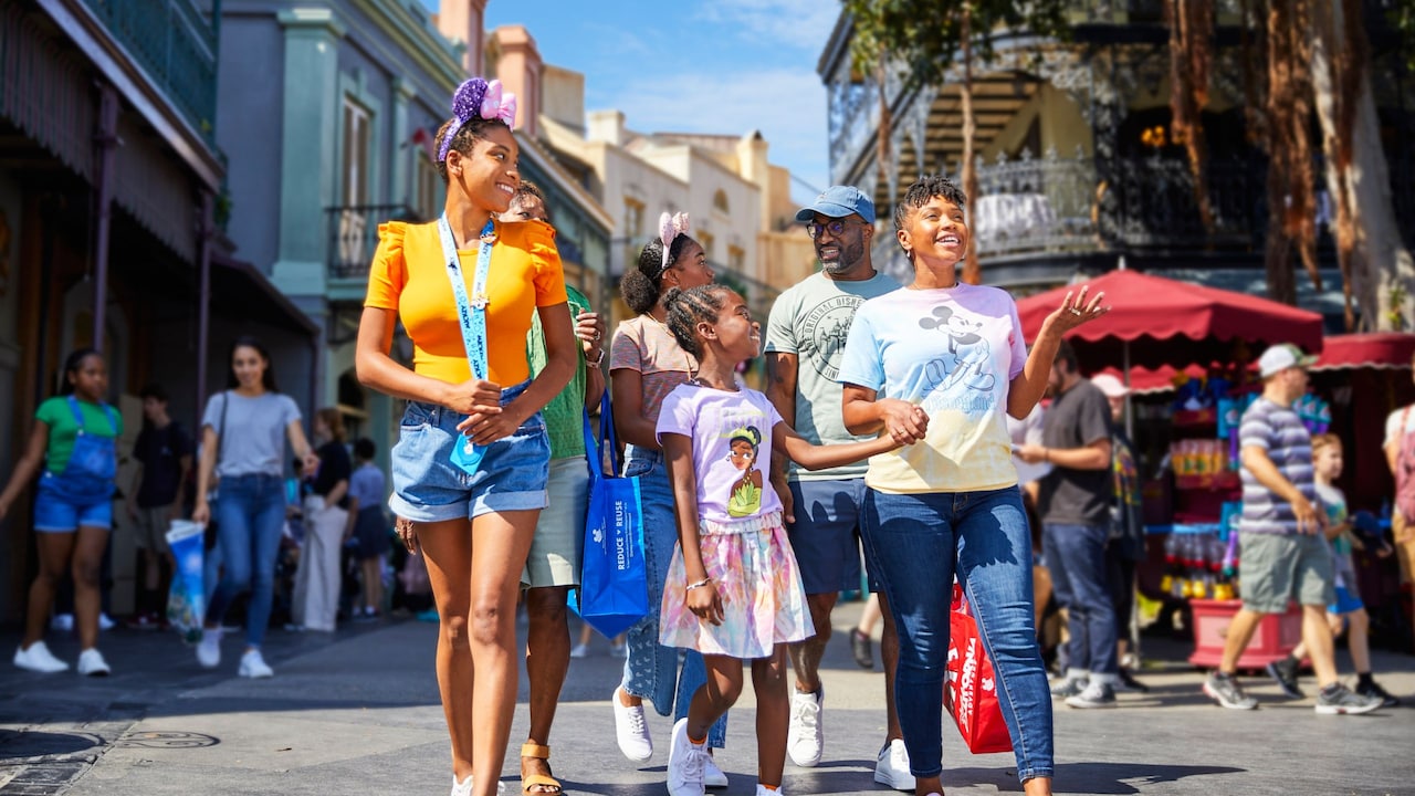 A family holding hands and walking on Main Street, USA