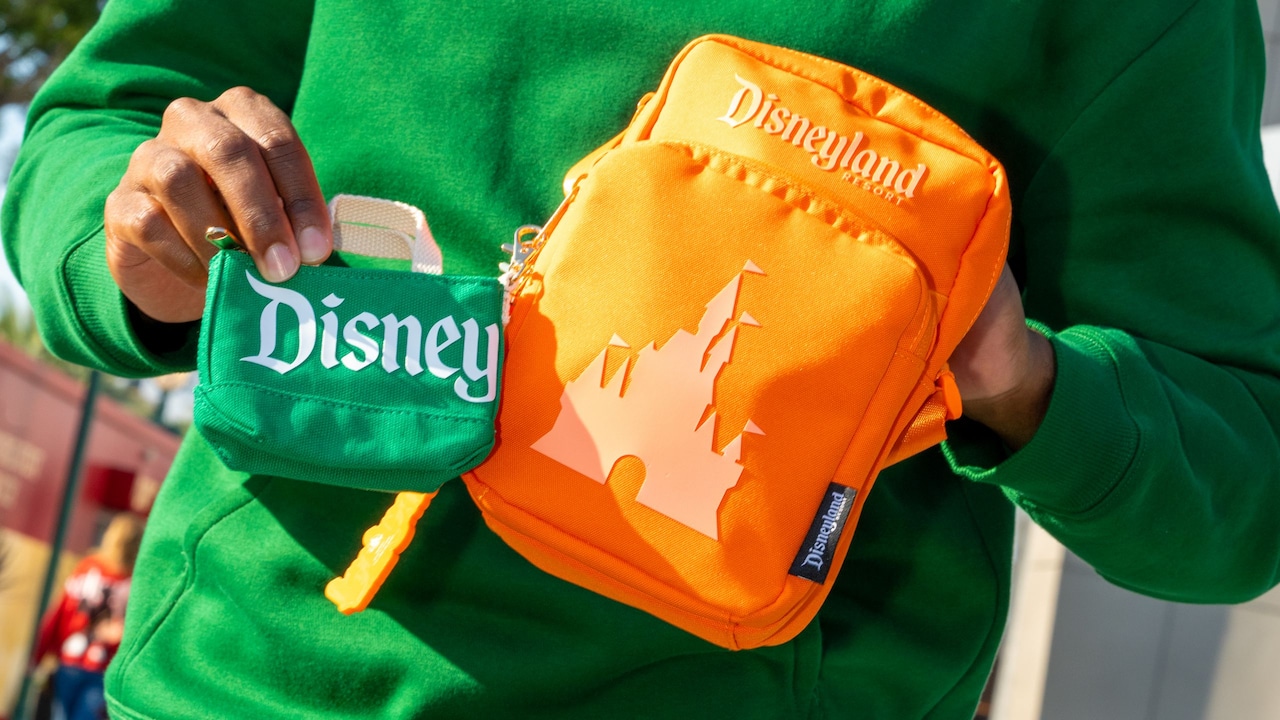 A man modeling a Logo Mania merchandise collection sweatshirt, bag and backpack during Disney on the Yard Yardfest 2026
