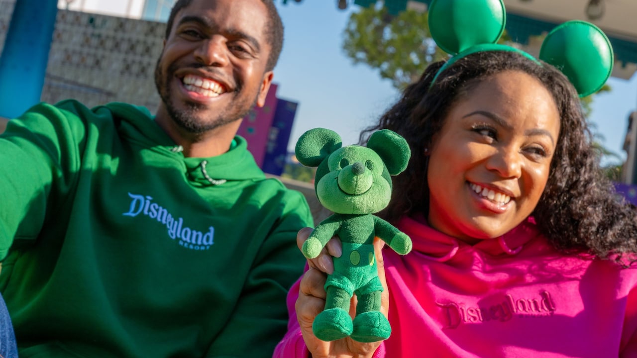 A man, a woman and their Mickey Mouse plush toy from the Logo Mania merchandise collection