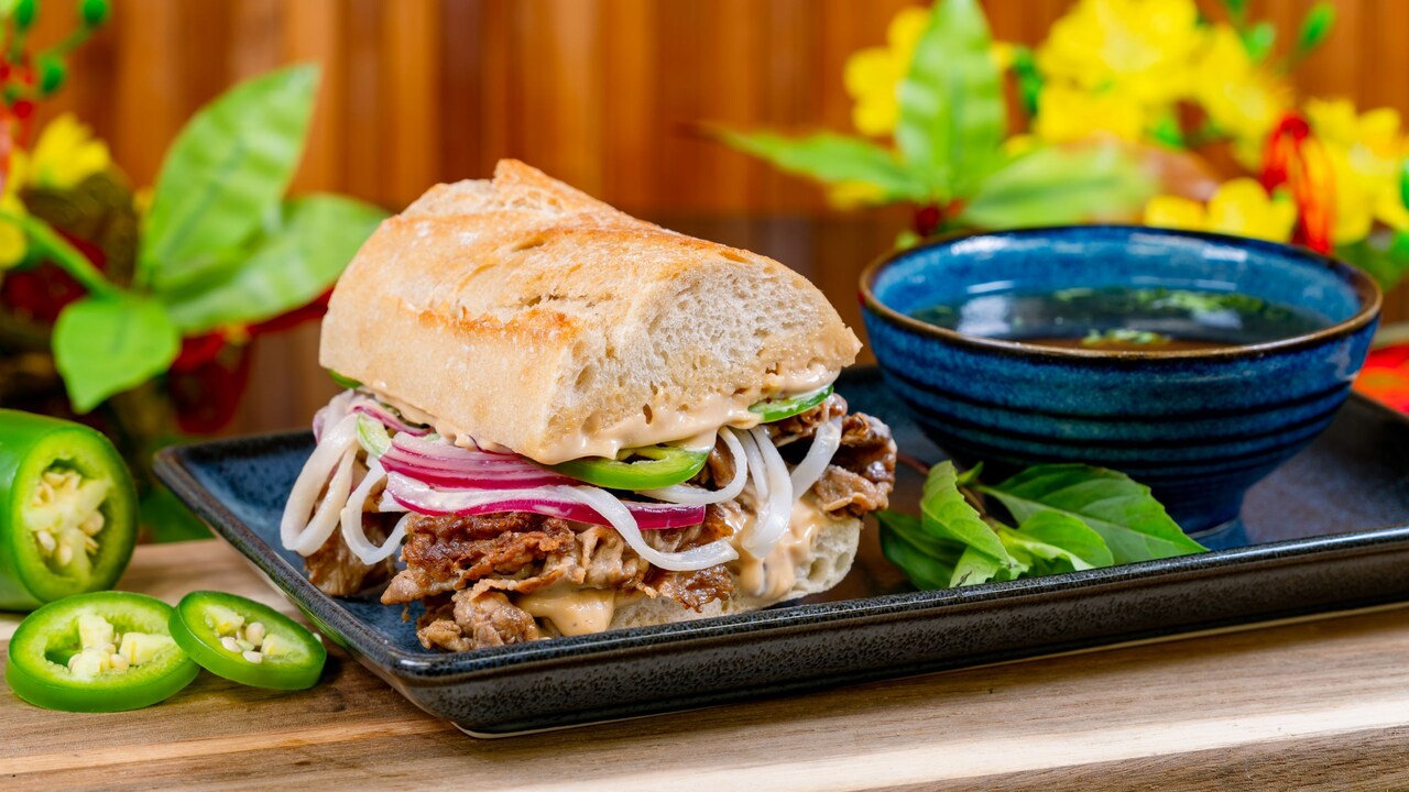 A Pho Dip sandwich served on a plate with a dipping bowl