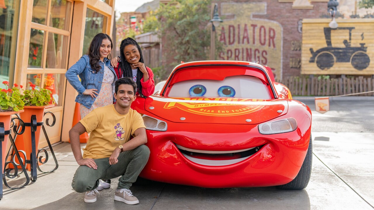 Three Guests posing with Lightning McQueen in Cars Land